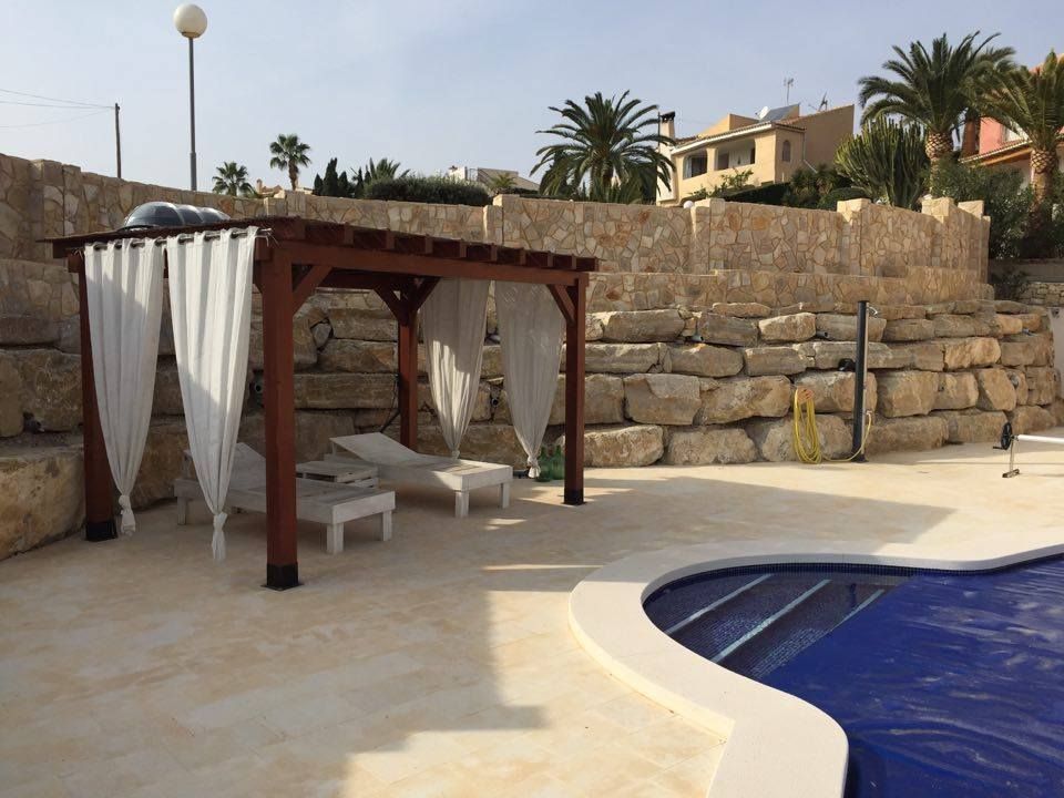 Construcción de muro de escollera de piedra natural junto a una piscina en Coveta Fumá (El Campello, Alicante)